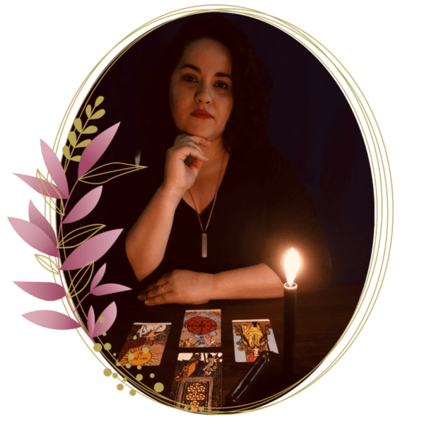 Vanessa está sob uma mesa com cartas de Tarot dispostas à sua frente e a luz de velas.